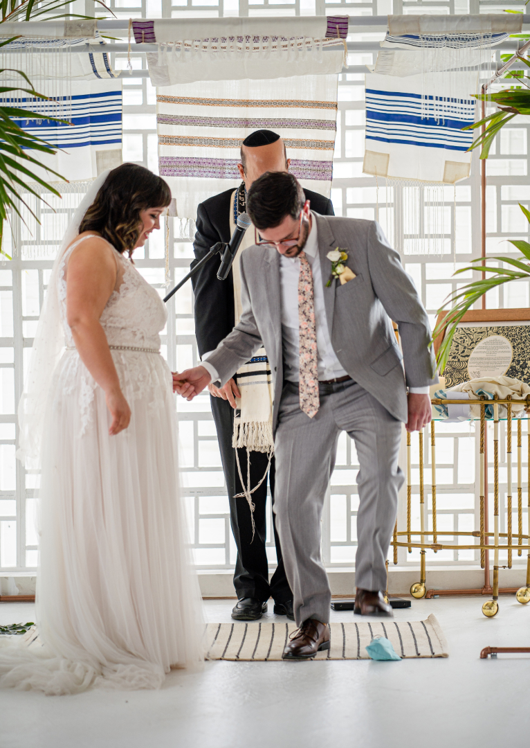 A groom breaking a glass at a Jewish wedding ceremony in the Gallery 