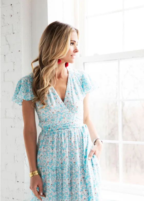 A guest in a light blue party dress looking out the window in the Gallery