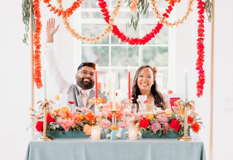 Bride and groom at a colorful sweetheart table in the Gallery