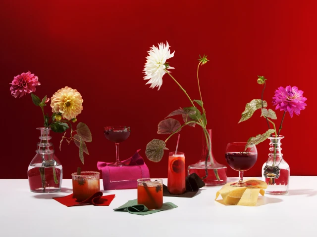 Vibrant red cocktail party vignette with vases and glasses