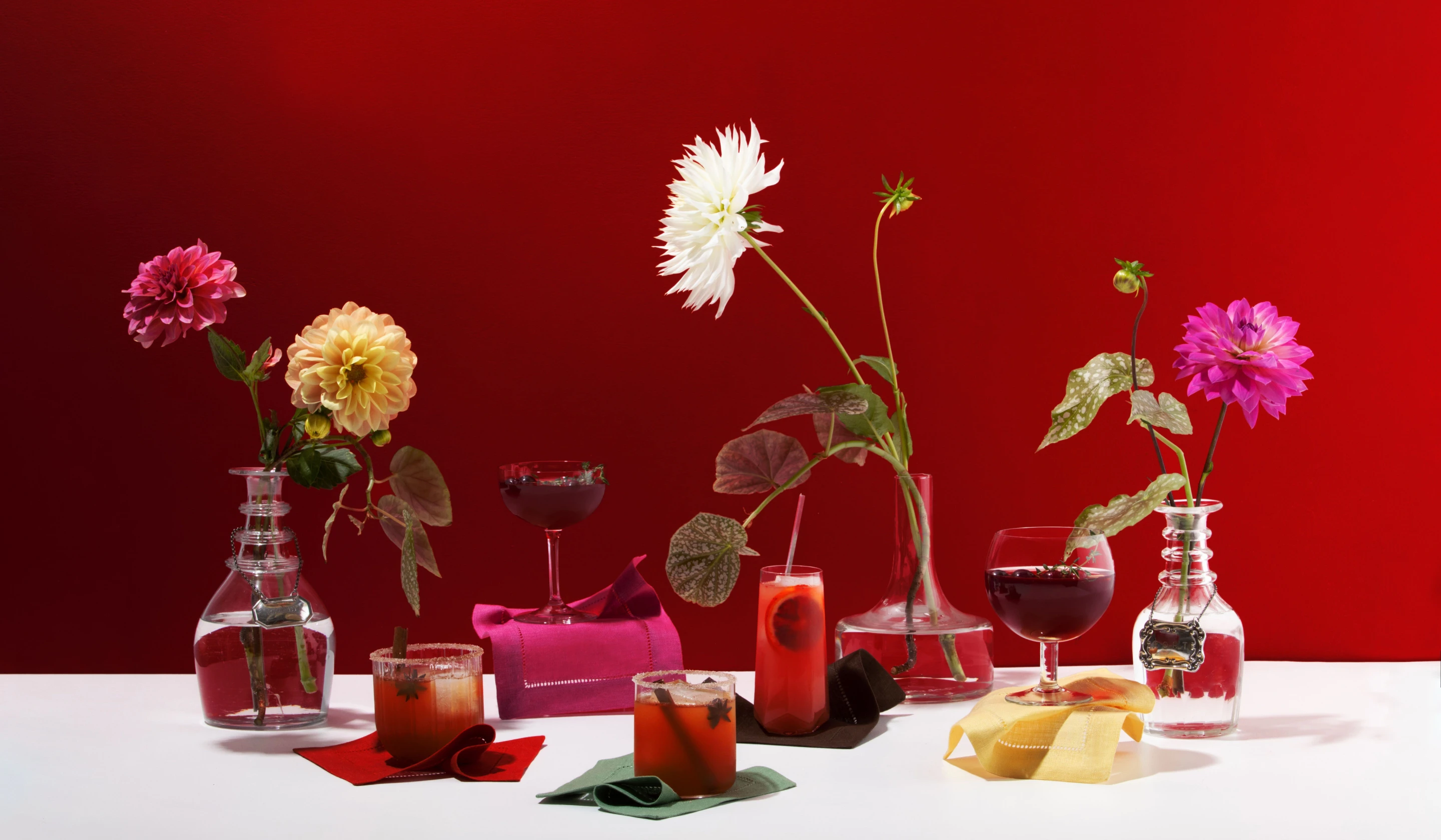 Vibrant red cocktail party vignette with vases and glasses