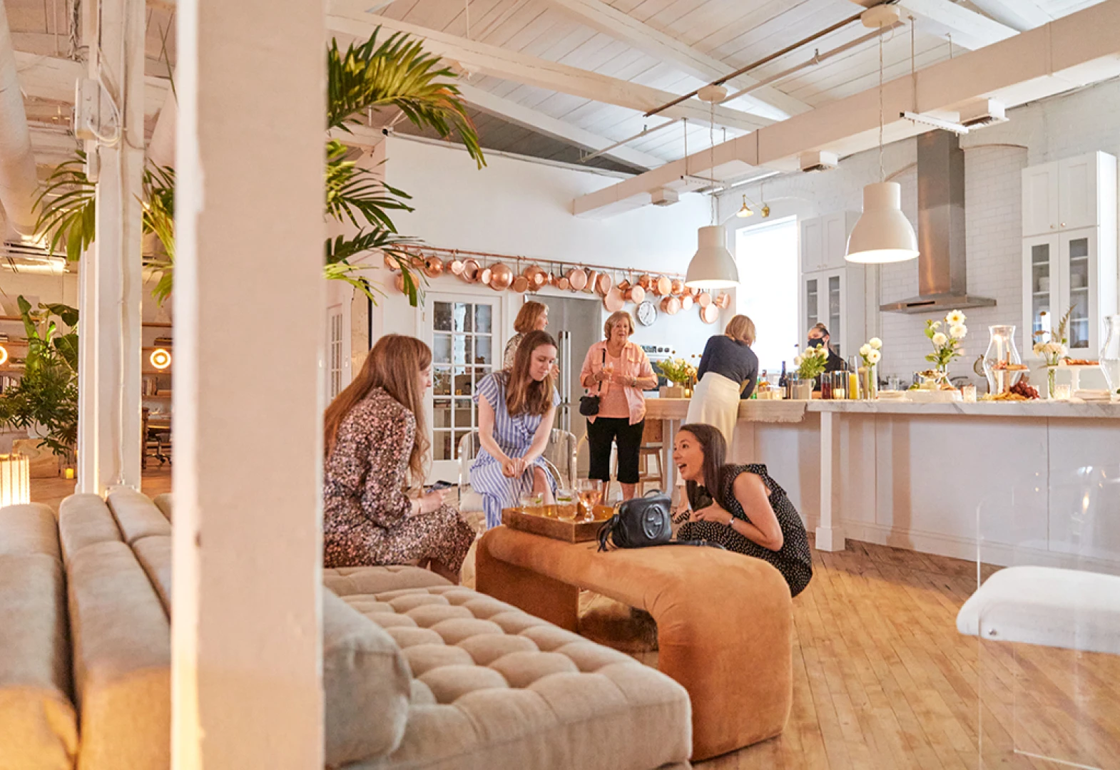 Guests lounging in the Loft with the Kitchen in the background 