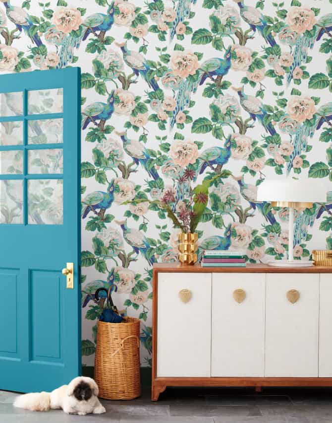 Foyer set with blue door and large floral print with pekingese pup on floor