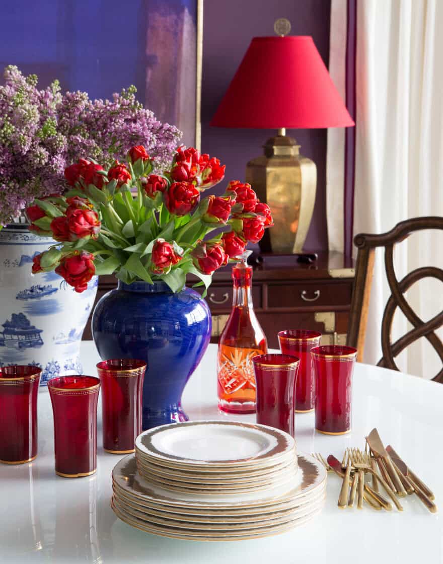 Dining room vignette with lilacs, tulips and tableware for spring table setting