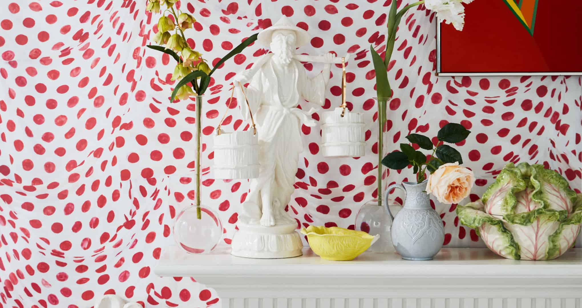 Exuberant red-and-white wallpaper behind a crisp white mantle