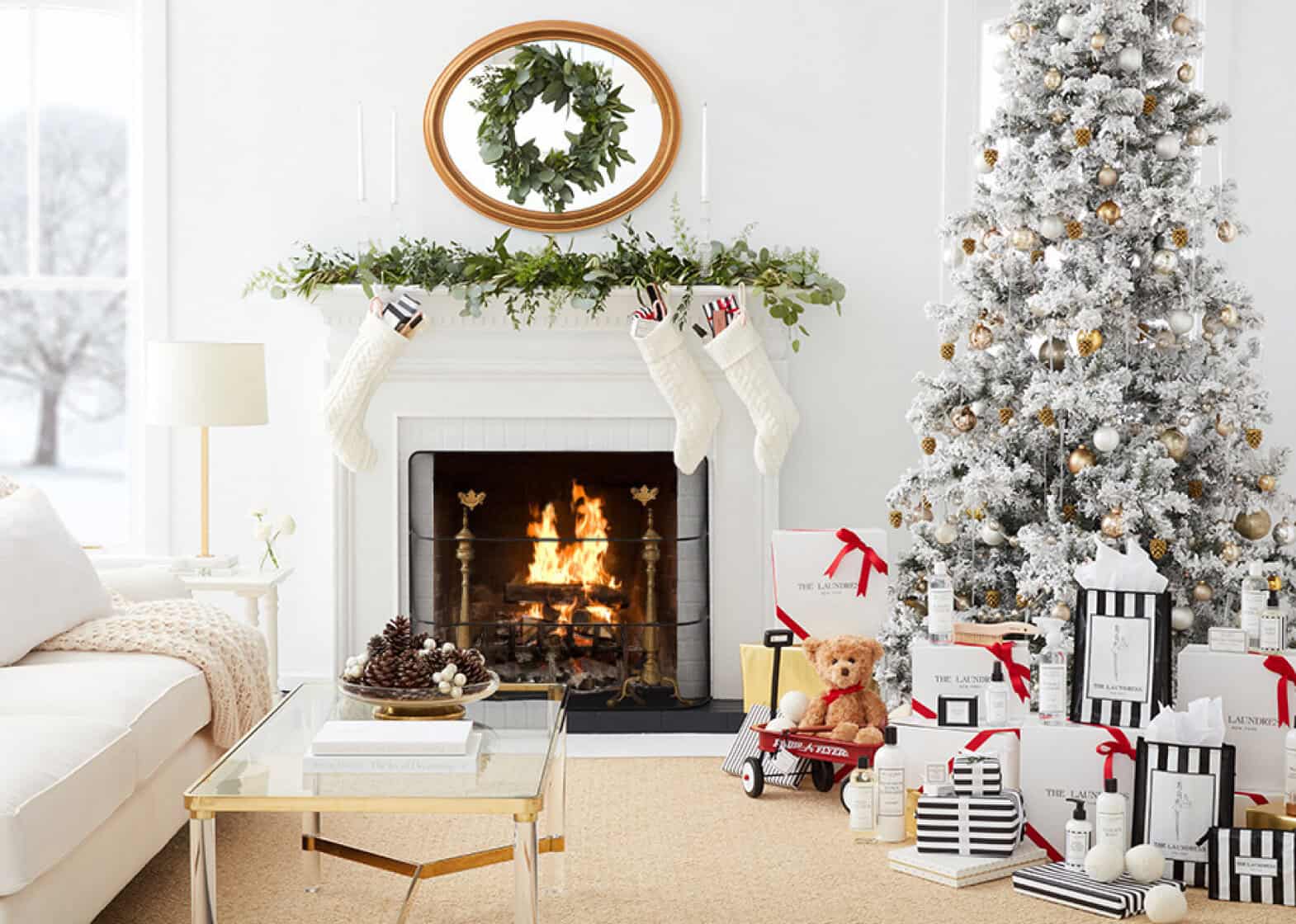 Living room set decorated for Christmas with a crackling fire and winter scene outside