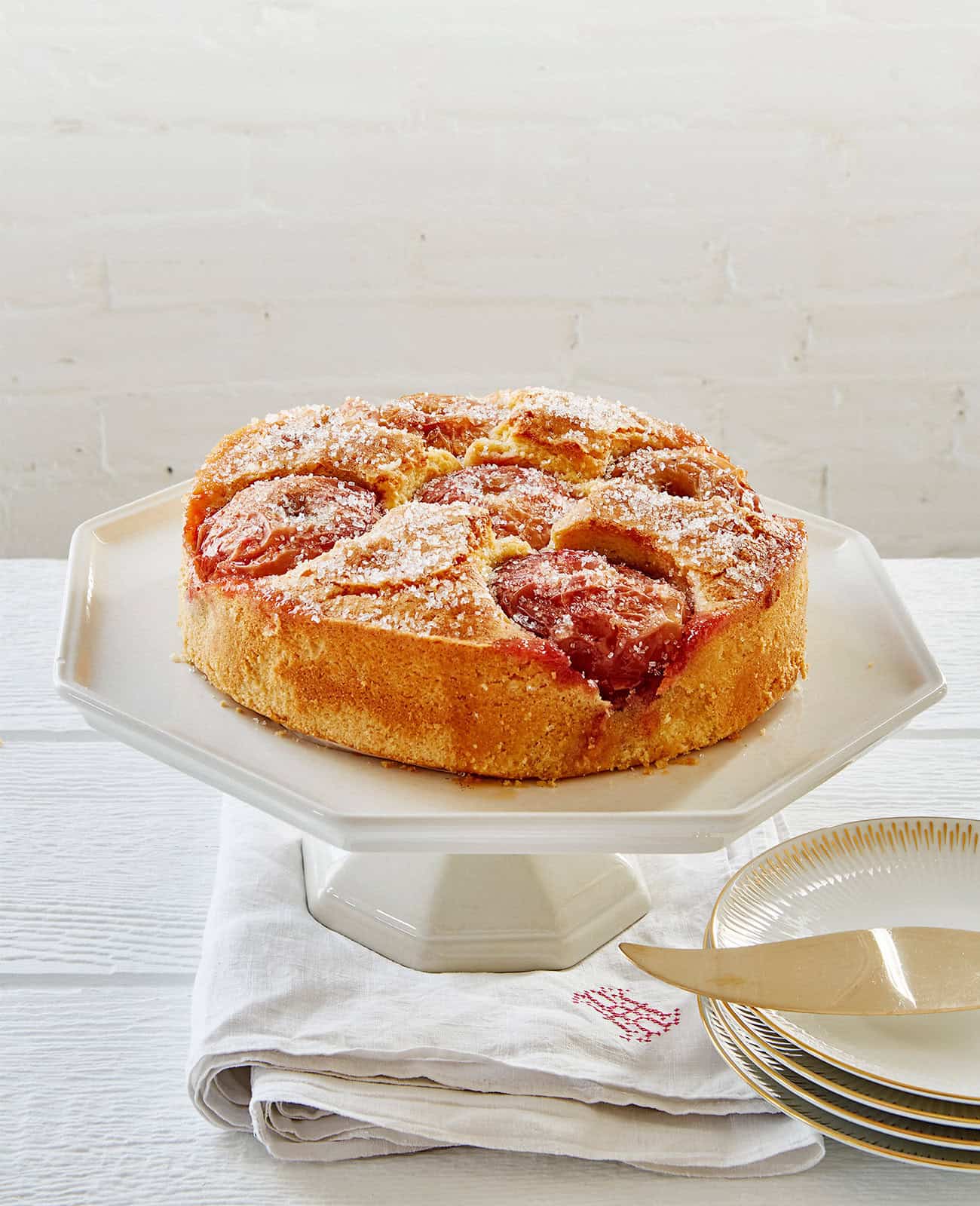 Apple crumb cake on a white pedestal