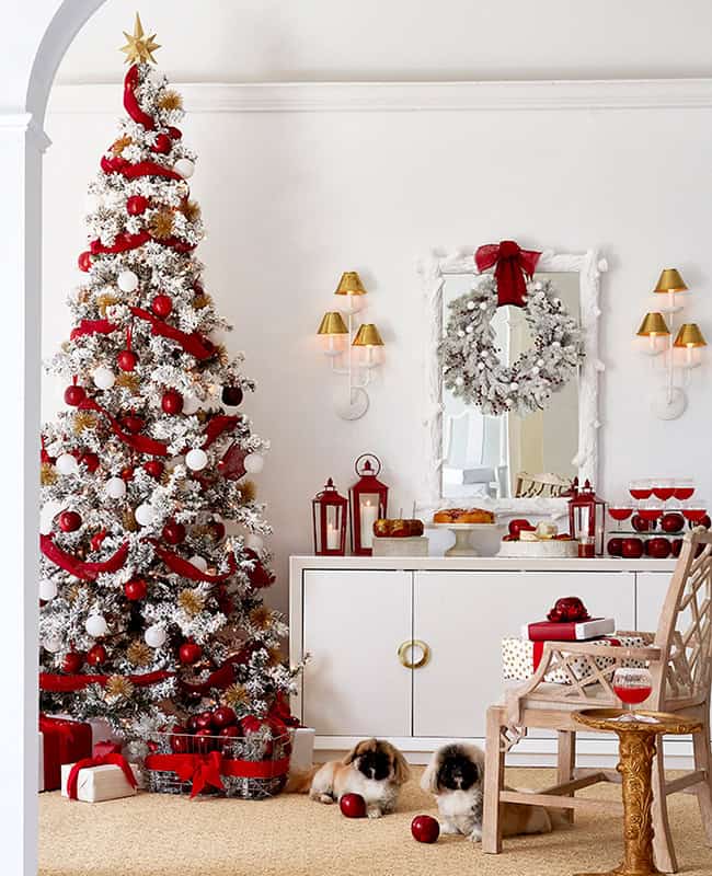 Dining room vignette of Christmas tree decorated with apples with two pekinese pups