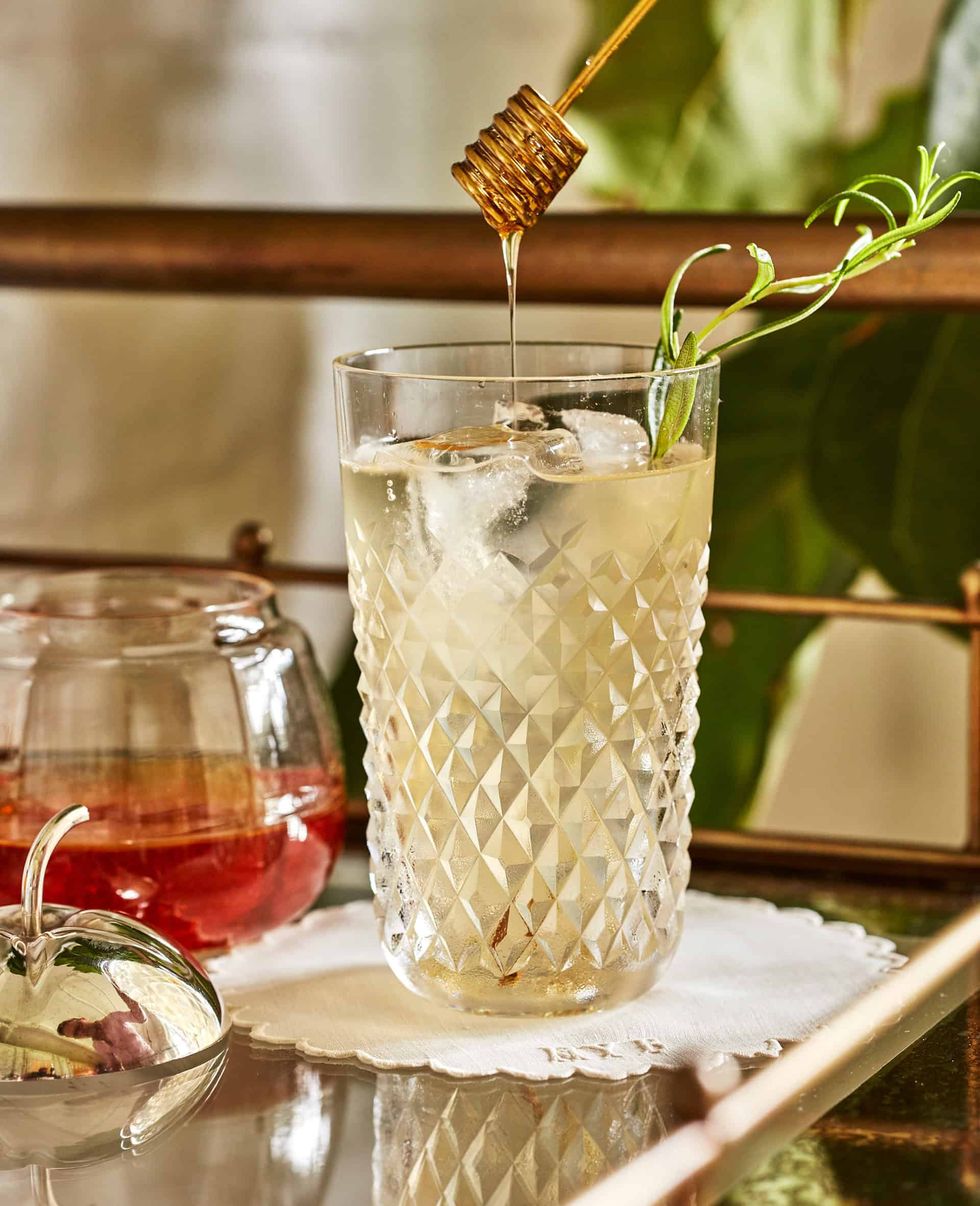 Cocktail in vintage glassware on a bar cart