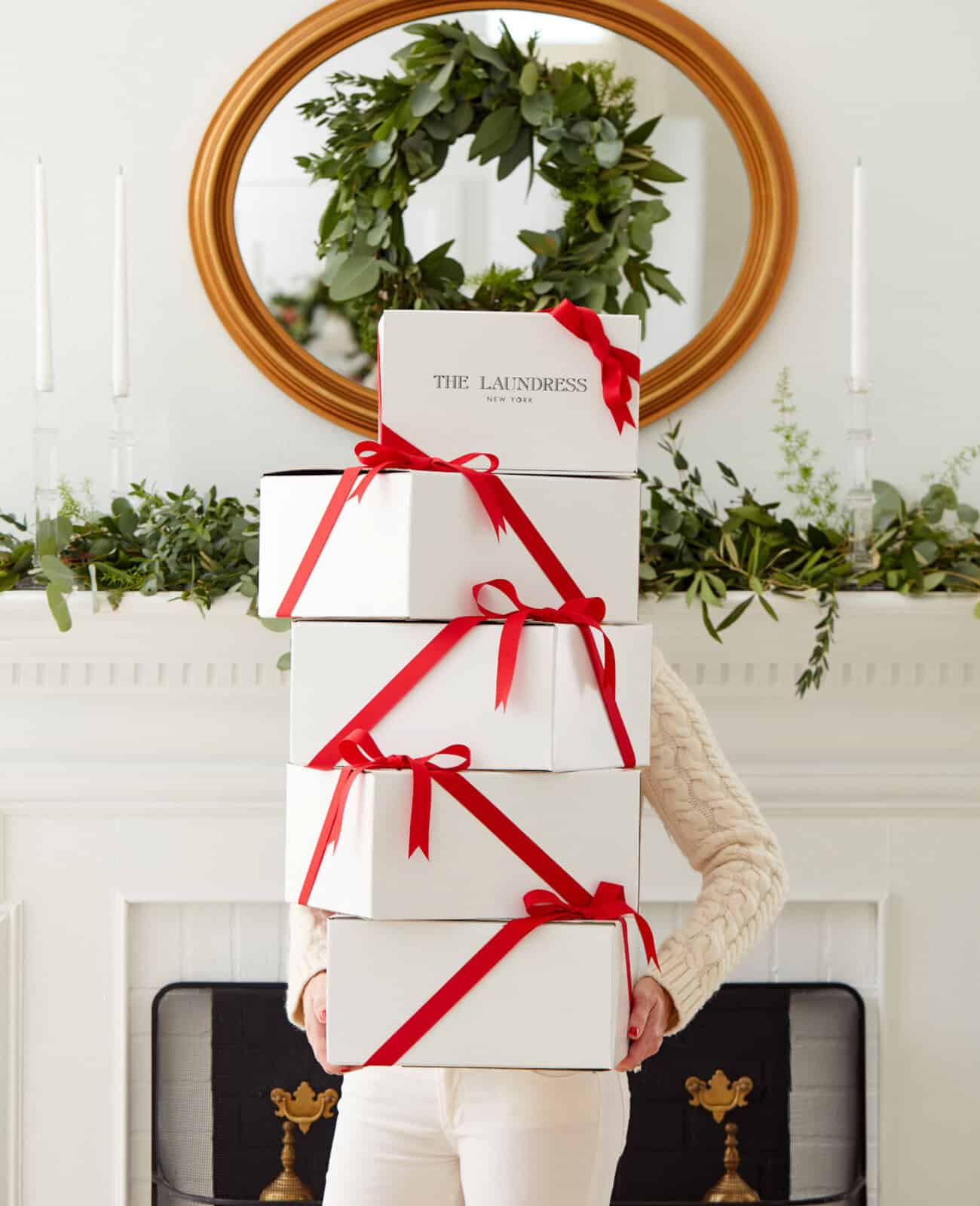 Female model holding a stack of Christmas presents