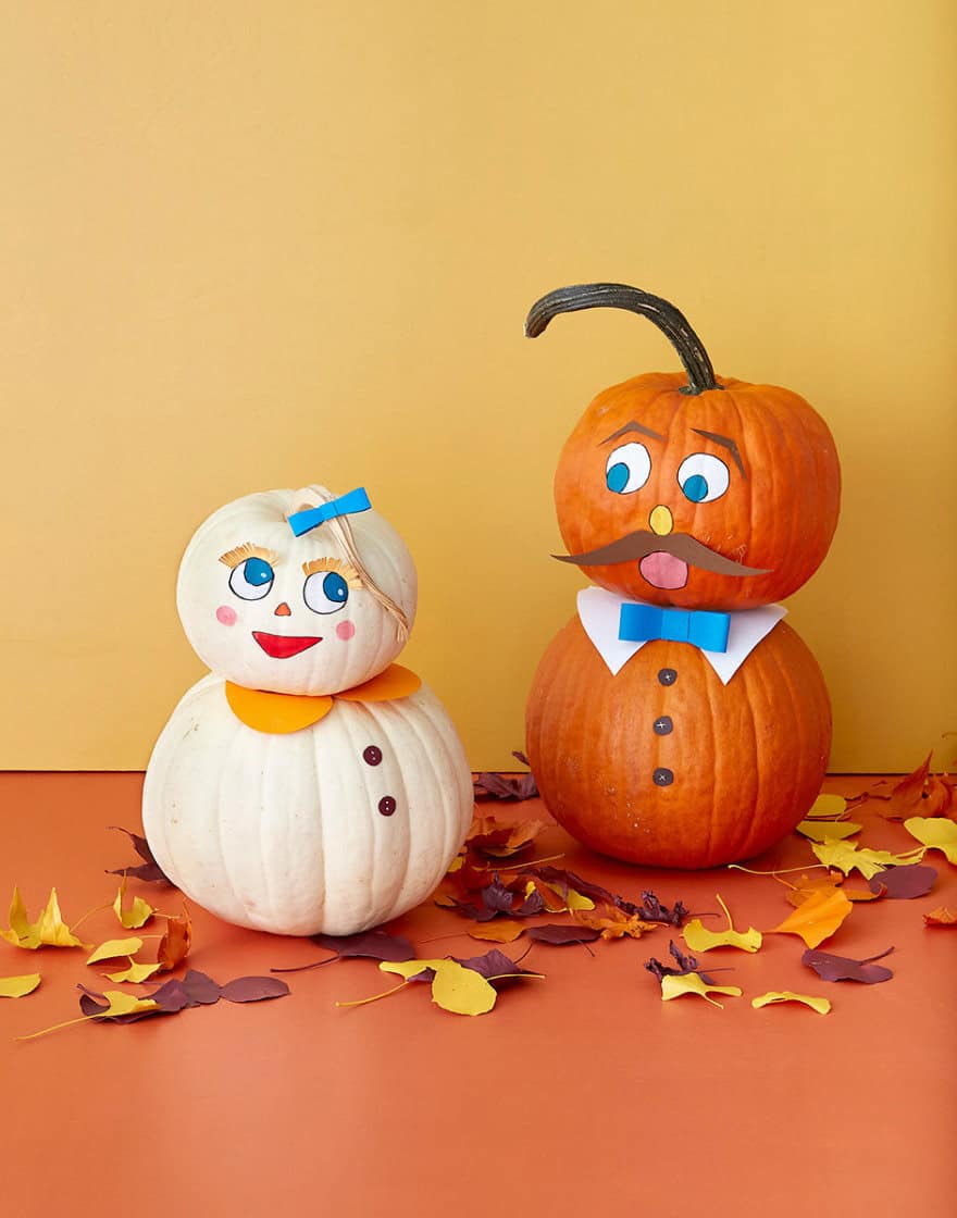 Two pumpkin figures made with painted faces and paper cutouts