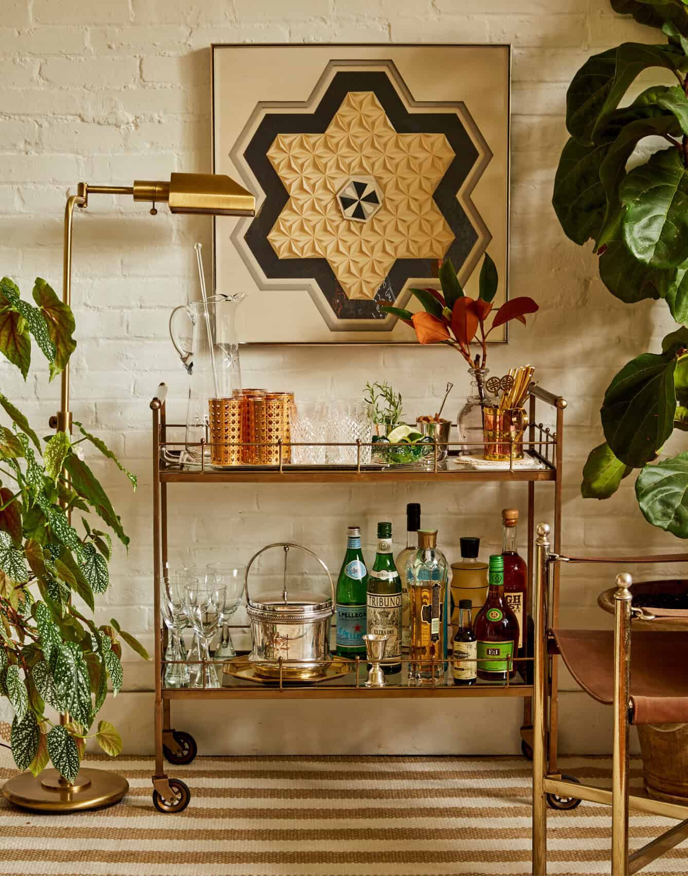 Bar cart vignette against white brick wall