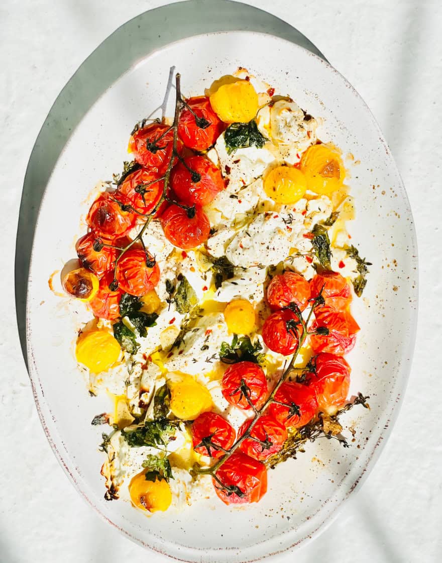 Overhead of platter with roasted tomatoes on the vine and ricotta