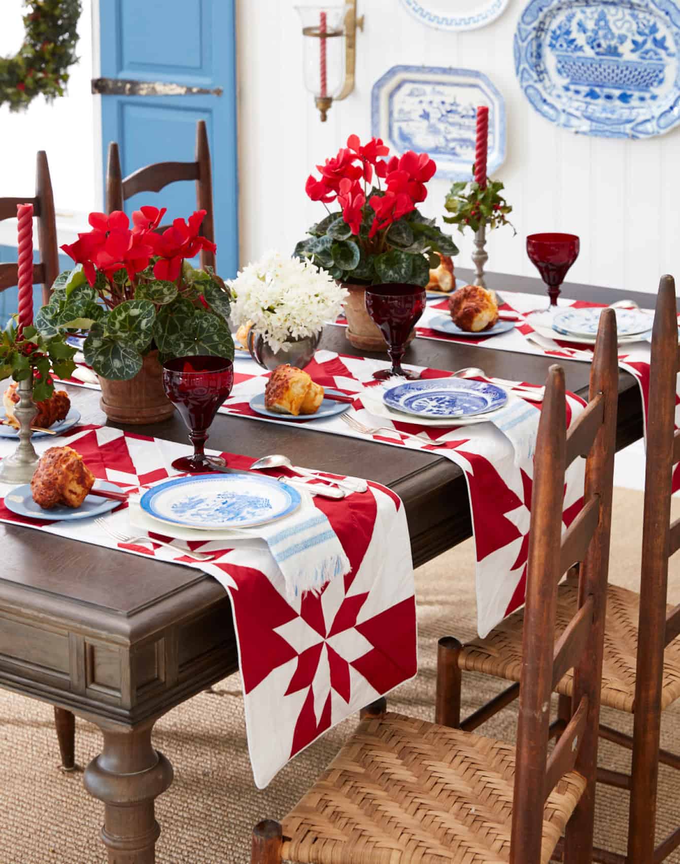 Dining room set with quilted red runners and blue transferware plates