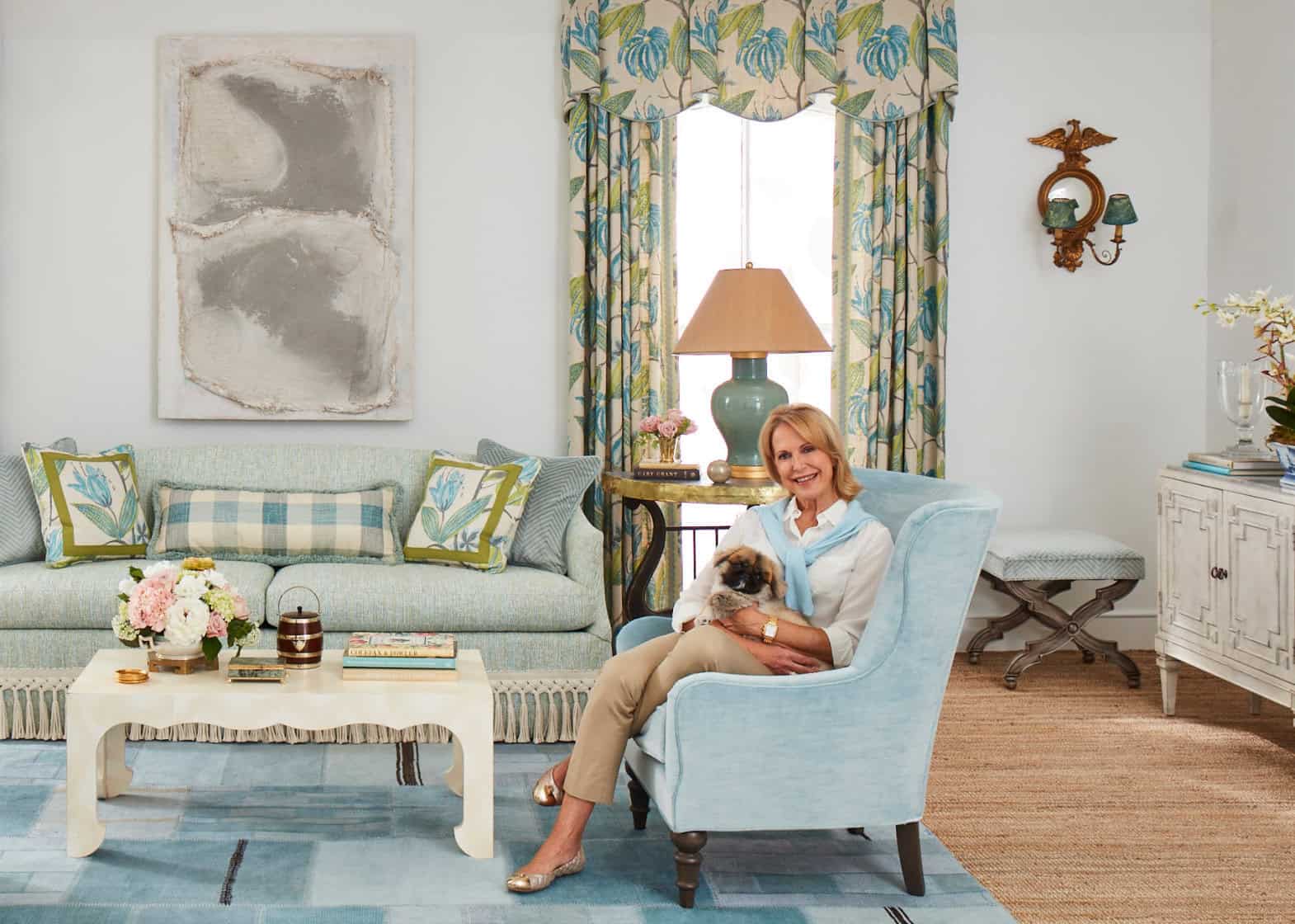 Living room set in blues, white and greens with female model holding puppy