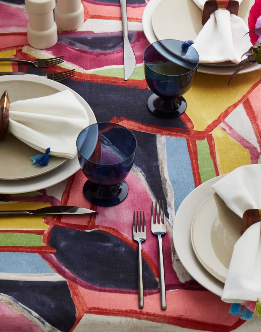 Overhead of table setting with brightly colored tablecloth in a painterly print