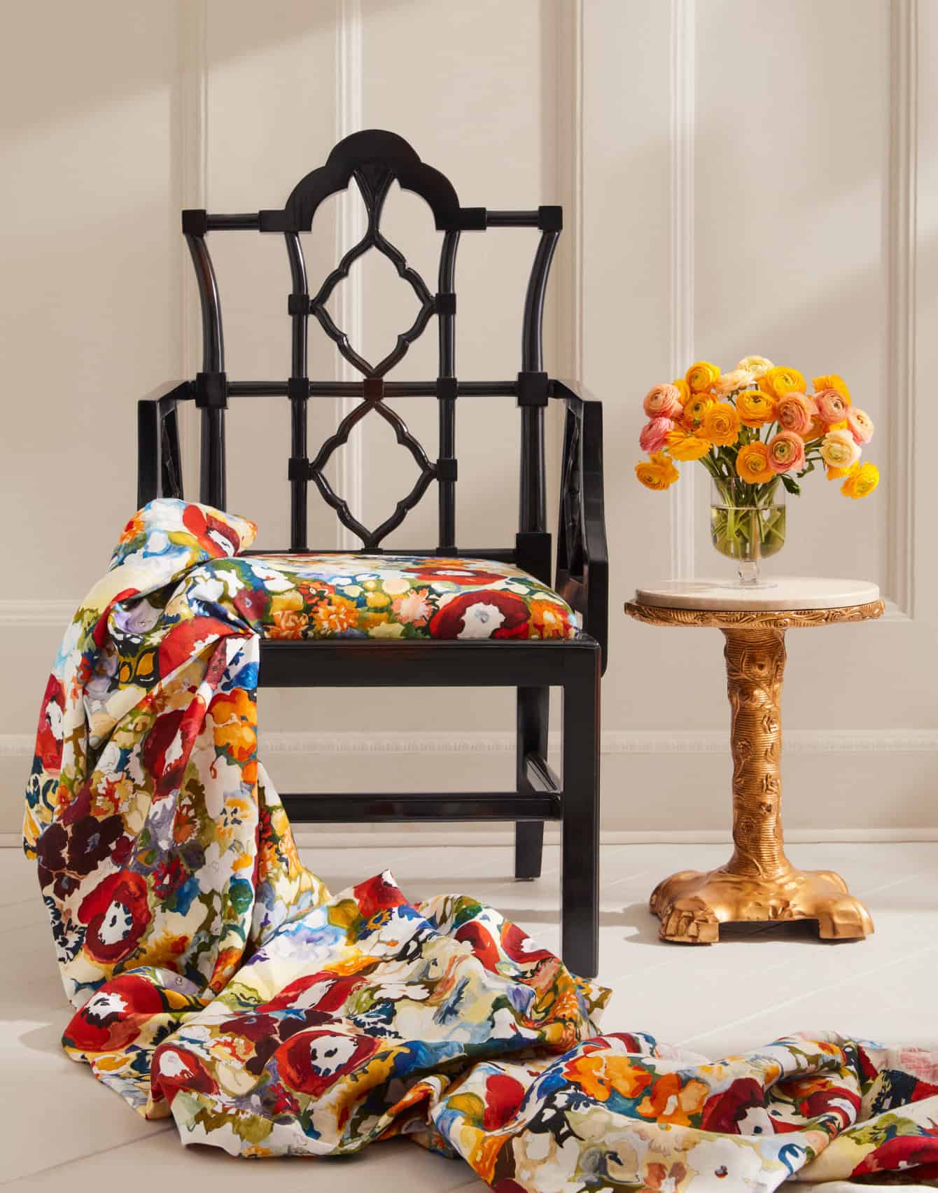 Multi-colored floral fabric on black chair, cascading to floor