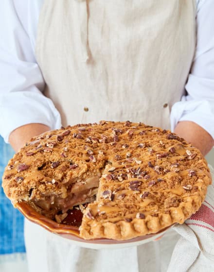 Pastry chef holding apple caramel pecan pie