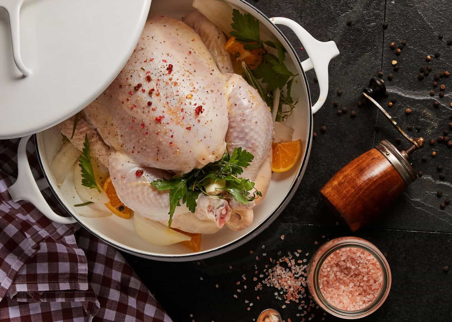 Overhead of fresh chicken in a pot about to be roasted in the oven